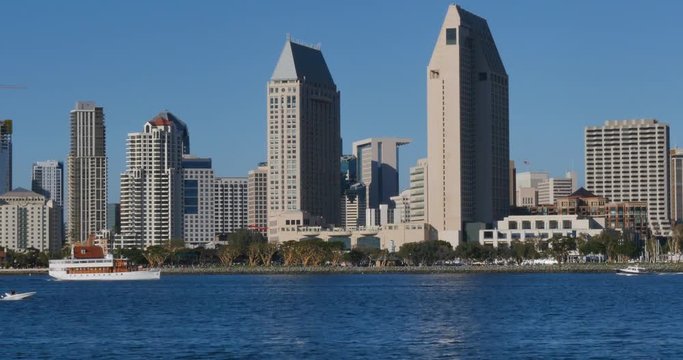 SAN DIEGO, CA - Circa February, 2017 - A daytime establishing shot of the San Diego skyline as seen from Coronado Island shoreline as boaters pass by in the bay.	 	
