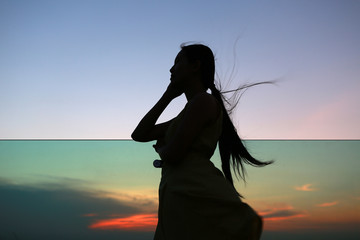 Silhouette of woman relax at sunset on rooftop of the building