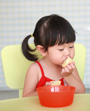 Asian Child girl play and eating boiled egg at living room