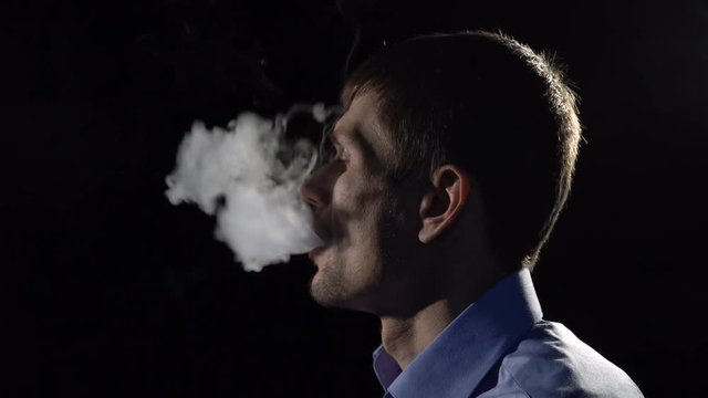 A man smokes an electronic cigarette