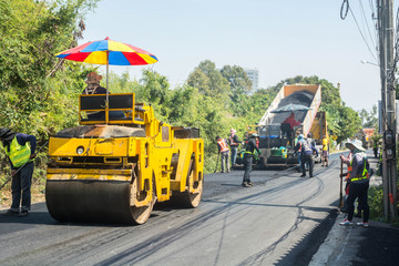 Naklejka premium Road Paving by workers and asphalting machines
