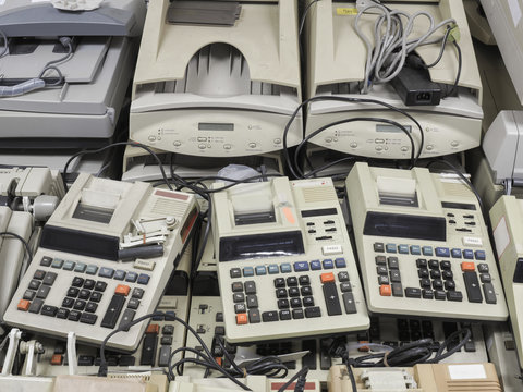 High resolution wide shot of disposed old cashier machines and printers that are waiting for discount sale. These calculator printers are outdated and waiting to be sold as office junk or trash.