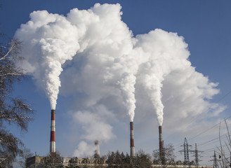 Smoking industrial chimneys. Combined heat and power. Air pollution clouds of smoke coming from the chimneys. Energy plant