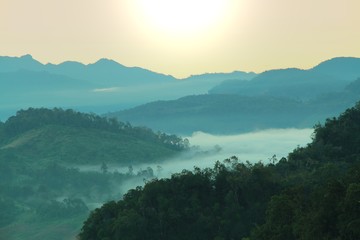 Morning mountain landscape with waves of fog at baan ja bo, Mae Hong Son, Northern Thailand. Waves of clouds in the mountain peaks covered with coniferous deciduous forests