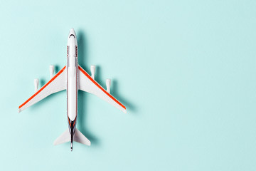 White toy plane on light blue background. Top view