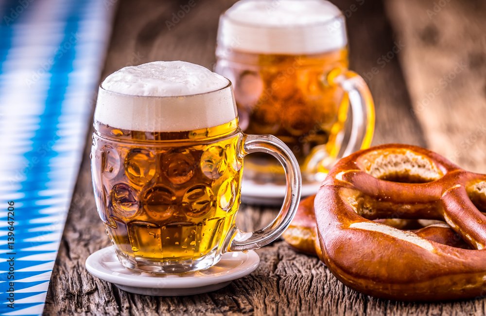 Wall mural Beer. Oktoberfest.Two cold beers and pretzel. Draft beer. But draft. Golden beer. Golden however. Two gold beer with froth on top. Cold draft beer in glass jars in a hotel pub or restaurant.