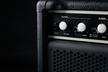 Electric bass Guitar black leather Amplifier on black Background.