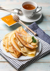 Pancake stack filled with banana slices and honey