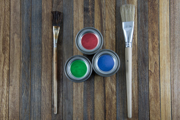 Home improvement, colorful paint cans on the clear wooden background