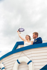 Obraz premium Wedding couple on small boat. The bride and groom on the ship