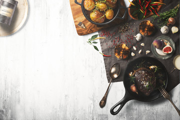 Overhead view of colorful roast vegetables, savory sauces and salt served with grilled t-bone steak on a rustic wooden counter in a country steakhouse created digital illustration