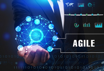 Business, Technology, Internet and network concept. Young businessman working on a virtual screen of the future and sees the inscription: Agile