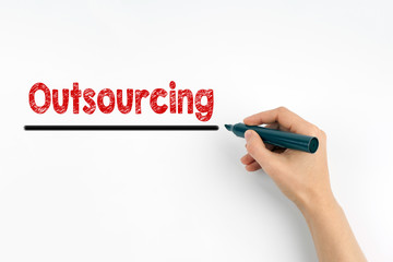 Hand with marker writing - Outsourcing concept. White paper background