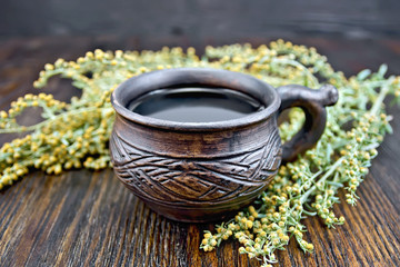 Tea with wormwood in cup on board