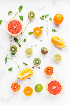 Colorful fresh fruit on white table. Orange, tangerine, lime, kiwi, grapefruit. Fruit background. Summer food concept. Flat lay, top view