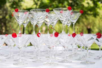 Close-up of the champagne pyramid with a red cherry at the top of each glassGlass goblets. Pyramid of champagne. A celebratory drink. Decorations for the Banquet.