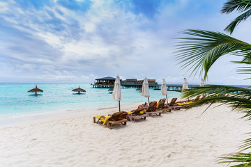 Tourists relaxing on the beach in tropical Maldives island