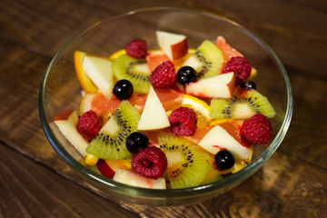 Delicious fruits salad in plate on table close-up