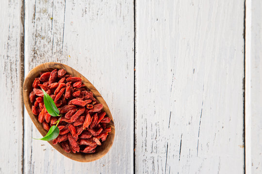 Dry goji berry on old white wooden background.