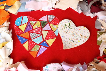 Two heart. Ceramic and textile of multicolored embroidered patches on red cloth on multi-colored pieces of fabric background. Love, romance and creativity