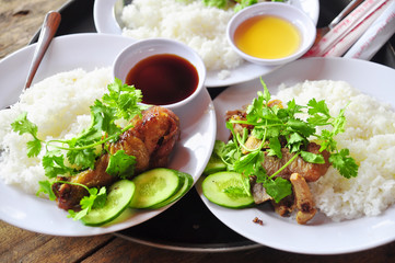 Vietnamese broken rice or com tam with fried chicken legs, pork and herbs