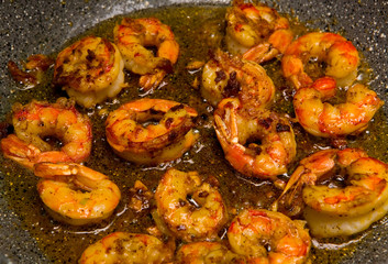 Delicious king prawns are fried in a frying pan.