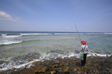 The local fishermen fishing on the rock July, 2016 : Senggigi beach in Lombok, Indonesia