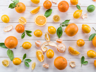 Ripe lemons and oranges on the white wooden table.