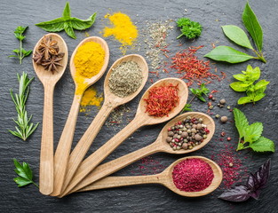 Assortment of colorful spices in the wooden spoons.