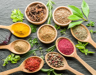 Assortment of colorful spices in the wooden spoons.