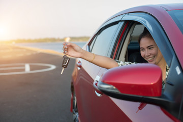 woman hand out window car red and car key with sunlight