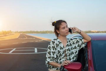 young woman playing mobile on the road