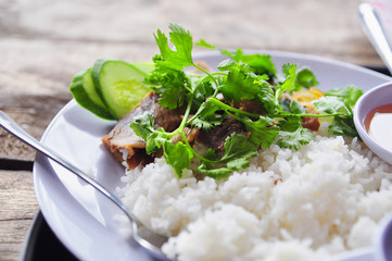 Vietnamese broken rice or com tam with fried chicken legs, pork and herbs