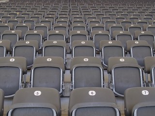 Rows of empty grey seats in an arena or stadium