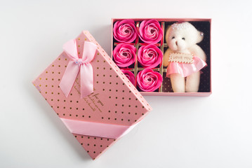 Gift in a pink box with lid on a white background,