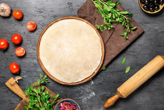 Raw pizza dough with set ingredients for cooking vegetarian pizza
