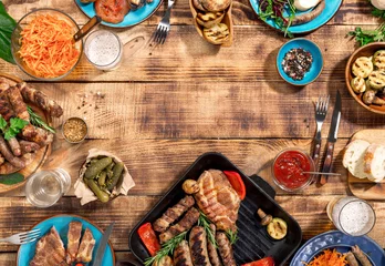 Fotobehang Gegrilde biefstuk, worstjes en gegrilde groenten op houten picknicktafel © kucherav