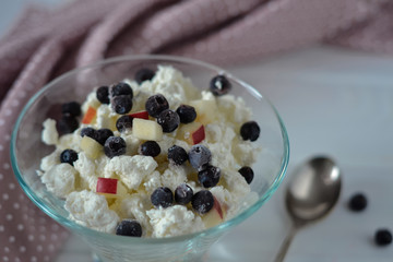 Healthy breakfast curd cheese and berries in glass bowl close-up