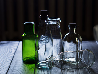 A set of glass empty bottles on dark wooden background