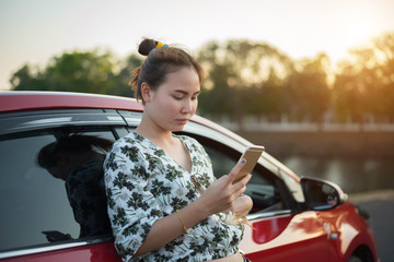 young woman playing mobile on the road
