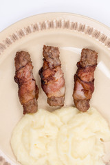 Grilled kebabs in bacon with mashed potatoes