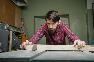 Fototapeta na wymiar Carpenter working with table saw in workshop