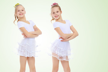2 girls gymnast in white suits.