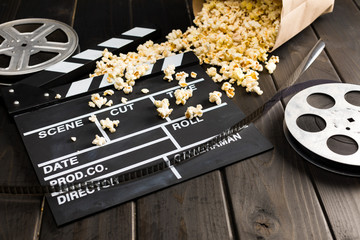 close up view of popcorn in paper container and movie clapper board on table, Movie time concept