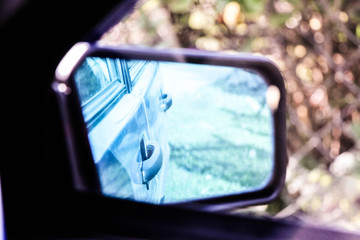 The reflection in the mirror of a car