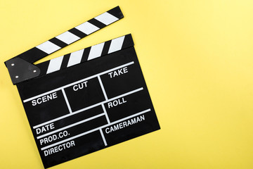 Fototapeta na wymiar top view of movie clapper board on yellow