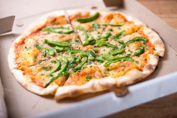 Italian pizza with green pepper in paper box tasty macro picture useful for background