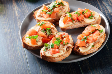 Appetizer bruschetta with tuna, mozarella cheese and tomatoes