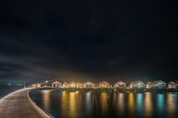 Luxury water villas in tropical Maldives island at night