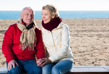 Mature couple sitting by sea